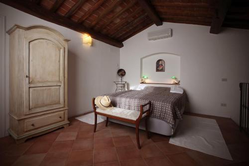 蒙泰斯佩尔托利Agriturismo Le Pianore的一间卧室配有一张床和一个木制橱柜