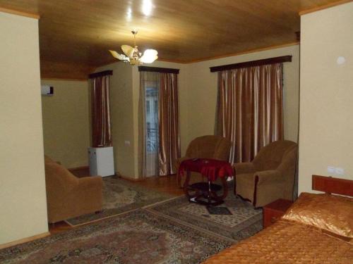 巴统hotel Pharnavaz的客厅配有床、椅子和桌子