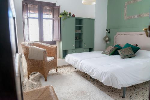 格拉纳达BENDITA CASA的一间卧室配有两张床和椅子