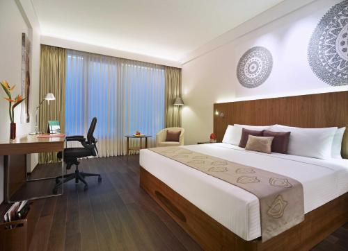 钦奈Vivanta Chennai IT Expressway OMR的配有一张床和一张书桌的酒店客房