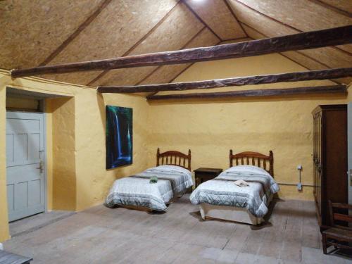 阿古伊梅斯Casa rural la cruz的配有木天花板的客房内的两张床