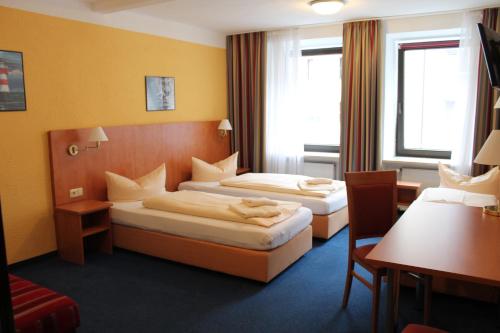 慕尼黑Hotel Margit的酒店客房设有两张床和一张桌子。