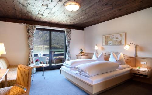 湖滨福煦西温克尔酒店的一间卧室设有一张大床和一个大窗户