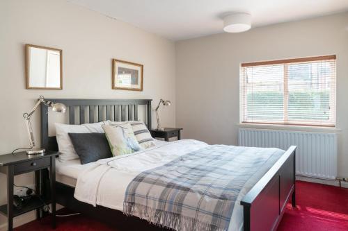 亨利昂泰晤士Henley self catering House的一间卧室设有一张大床和一个窗户。
