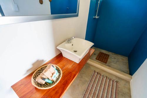 卡蒂马穆利洛Caprivi Mutoya Lodge and Campsite的铺有木地板,设有带白色水槽的浴室