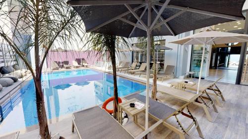 罗希姆诺美杜莎公寓式酒店的游泳池旁设有椅子和遮阳伞