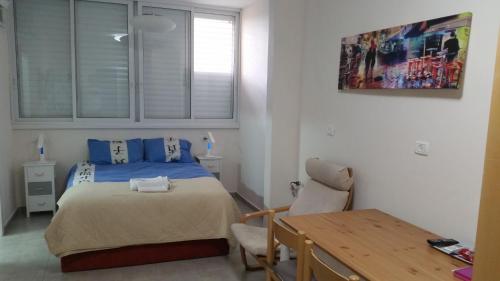 荷兹利亚Herzliya Center Apartments的一间卧室配有一张床、一张桌子和一张桌子