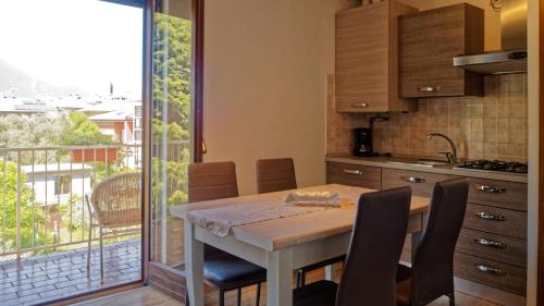 加尔达湖滨皇家住宅公寓式酒店 的一个带桌椅的厨房和一个阳台