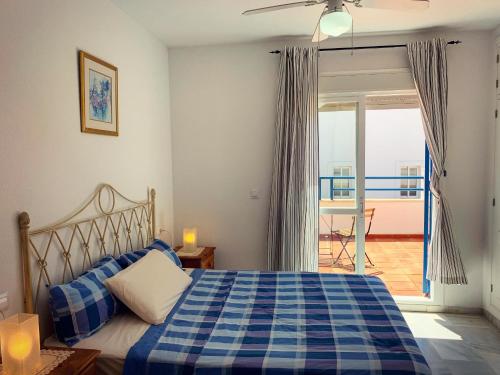 埃尔波提尔Fantastic 3-Bedroom Holiday Home including Tennis and Pool Near Golf Course的卧室配有蓝色和白色的床和阳台。