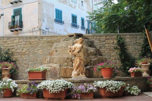 StiglianoHotel Ristorante Mariano的石墙前的雕像,有花盆