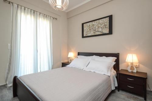 Glinado NaxosVilla Natalia的一间卧室配有一张带白色床单和两盏灯的床。
