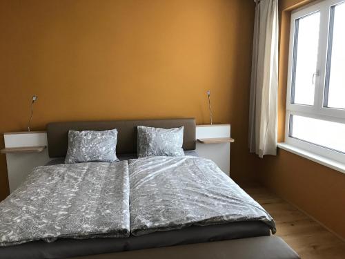 维也纳Spacious, Modern 1-bdrm Apt near VIC & Austria Ctr的一间卧室配有带两个枕头的床和窗户