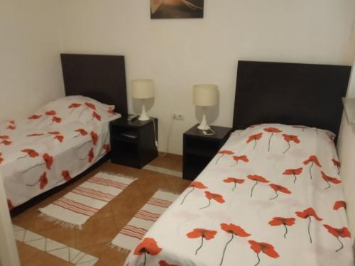 比尔杰卢特拉旅馆的一间卧室设有两张铺有红色叶子的床铺。
