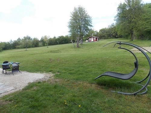MalaumontLes Gîtes De Morville的草上带长凳和雕塑的公园