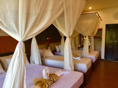 佩母德兰Villa Dika Pemuteran的一间设有四张床的房间,里面的人躺在床上