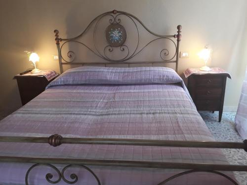 卡斯特尔萨多L'Antico Faro的一间卧室配有一张带2个床头柜的大床
