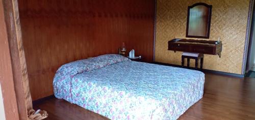 兰特包Toraja Torsina Hotel的一间卧室配有床、水槽和钢琴