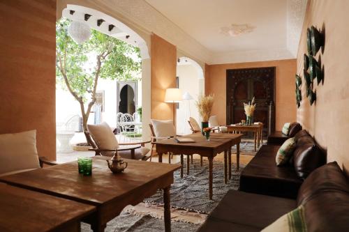 马拉喀什极乐鸟摩洛哥传统庭院住宅的客厅配有沙发和桌子