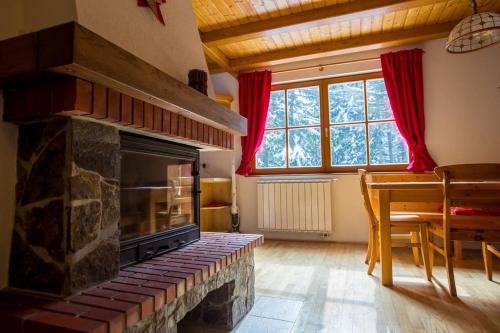 霍茨科波霍尔耶Bolfenk lodge apartment的客厅设有石制壁炉和桌子。