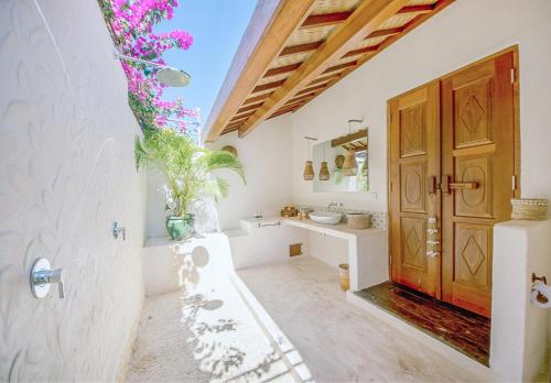 乌鲁瓦图姆玛热带住宿加早餐旅馆的一间带白色墙壁和木门的浴室