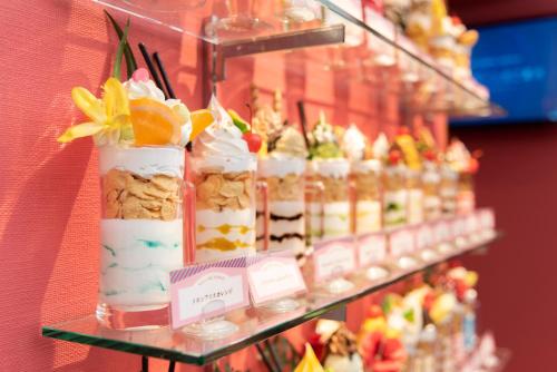 神户甜教堂酒店（仅限成人）的架子上展示甜点和糕点
