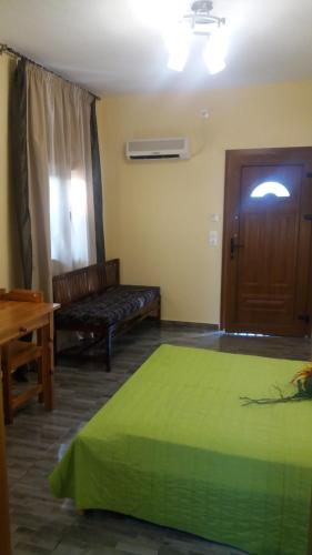 斯科派洛斯Stoudios galini的一间卧室设有一张绿色的床和一扇木门