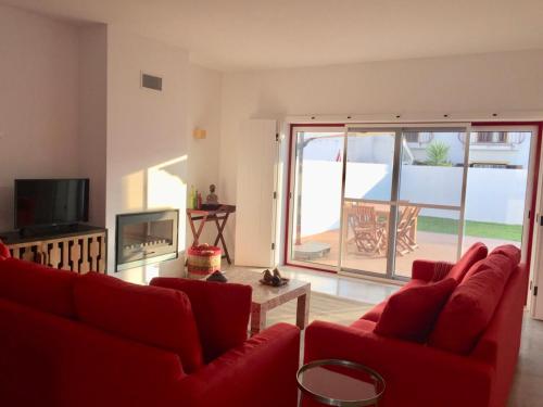 孔波尔塔Casa Oliveiras的客厅配有红色沙发和电视