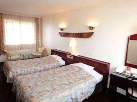 奄美奄美马车山村度假酒店的酒店客房,设有两张床和镜子