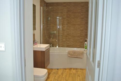 Wootton CourtenayHigher Brockwell Annexe的带浴缸、盥洗盆和卫生间的浴室