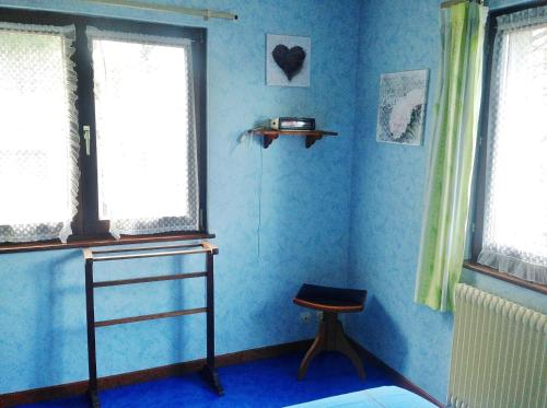 巴尔Chambres d'hôtes et Gîte chez Martine的蓝色的客房设有椅子和2扇窗户