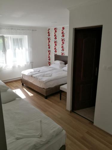 锡尔沃斯瓦里德Halász Vendégház的一间卧室配有两张床和镜子