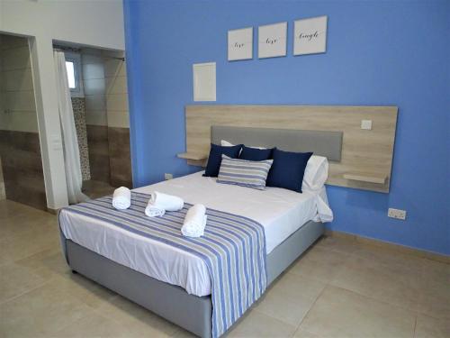 普罗塔拉斯Proteas Mare Suites的蓝色卧室,配有带2条毛巾的床