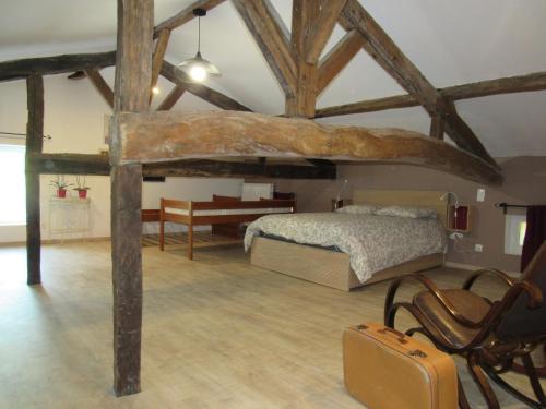 Pujols GirondeLa Maison des Graves的卧室配有1张床、1张桌子和1把椅子
