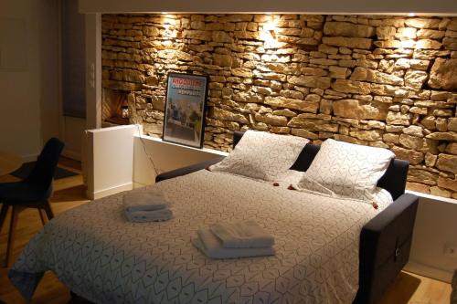La RochettePETIT GITE EN BRACONNE的石墙房间内的一张床位