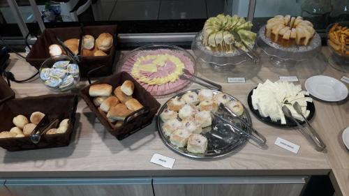 奥林匹亚Angelo Hotel的一张桌子,上面放着许多不同类型的蛋糕和糕点