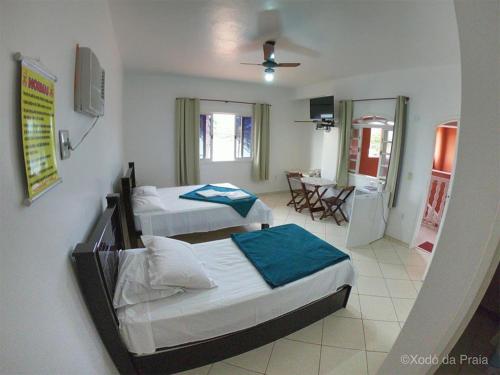 圣佩德罗-达阿尔德亚Pousada Xodó da Praia的一间带两张床的卧室和一间餐厅