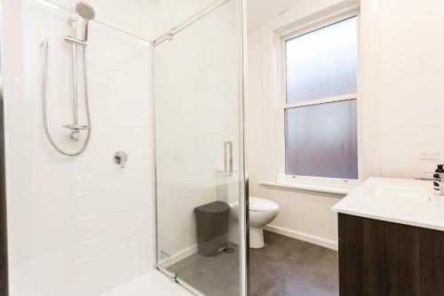 但尼丁The Stuart Street Terraced House的带淋浴和卫生间的白色浴室