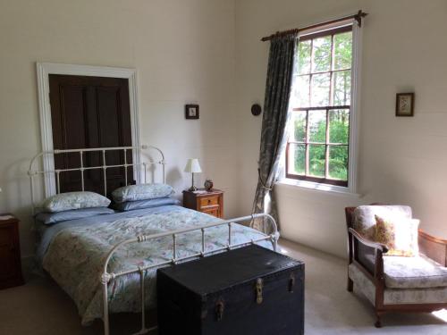 蒂阿瓦穆图老学校乡村民宿的卧室配有床、椅子和窗户。