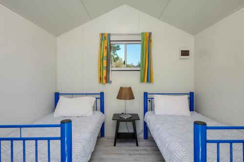 拜伦湾格伦别墅度假酒店的配有2张床的带窗户和桌子的客房