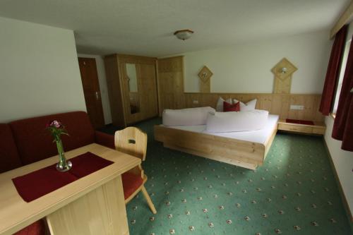 皮茨河谷圣莱昂哈德Haus Bödele的酒店客房配有一张床铺和一张桌子。