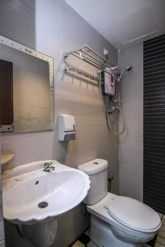新山Rose Cottage Hotel Taman Impian Senai的浴室配有白色卫生间和盥洗盆。