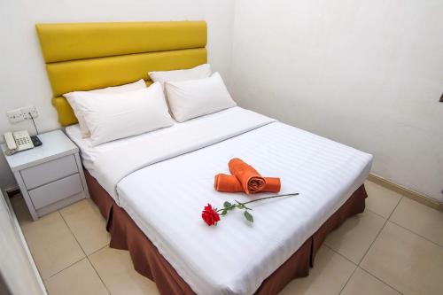 新山Rose Cottage Hotel Taman Impian Senai的一张黄色床头板和红色花床