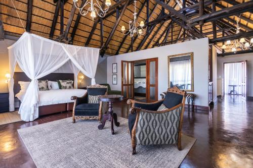 奥考奎约Epacha Game Lodge & Spa的卧室配有一张床和一张桌子及椅子
