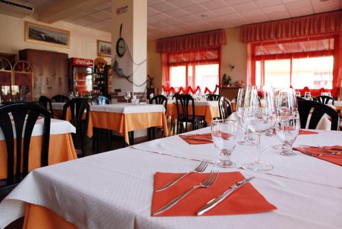 罗西尼亚诺－索尔瓦伊Piccolo Hotel的用餐室配有带玻璃杯和餐巾的白色桌子