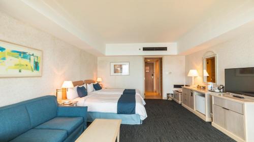 加拉班格兰德瑞奥塞班度假村的酒店客房,配有床和蓝色的沙发