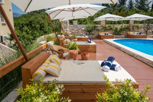 科尔丘拉Kis Residence - Adults Only的一个带遮阳伞和游泳池的庭院