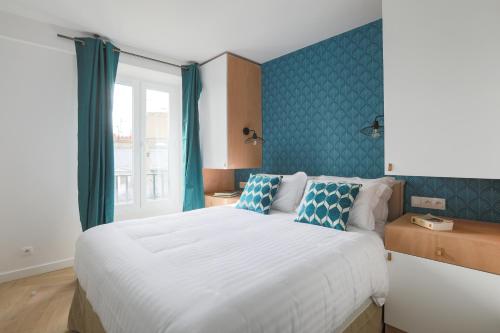 巴黎LE MATISSIA的卧室配有白色大床和蓝色的墙壁