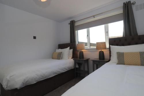 邓弗姆林Dunfermline - Luxury 3 bedroom 2 bathroom detached house with garden的带窗户的客房内的两张床