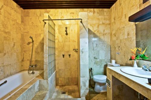 沙努尔Palm Garden Hotel的带浴缸、卫生间和盥洗盆的浴室