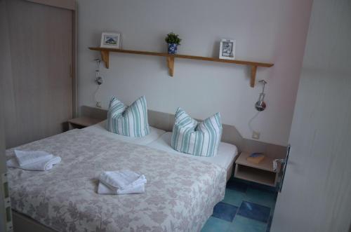 奥特里德维茨Luett-Osten-300-Meter-bis-zum-Strand的一间卧室配有一张带蓝色和白色枕头的床